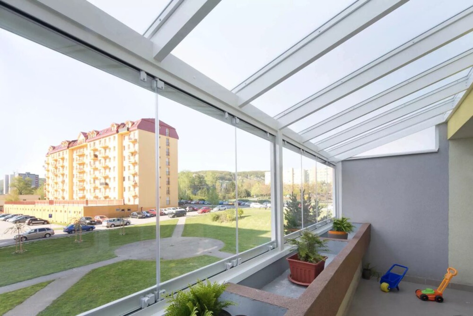 Vitrage moderne sans cadre donnant sur le quartier et la verdure