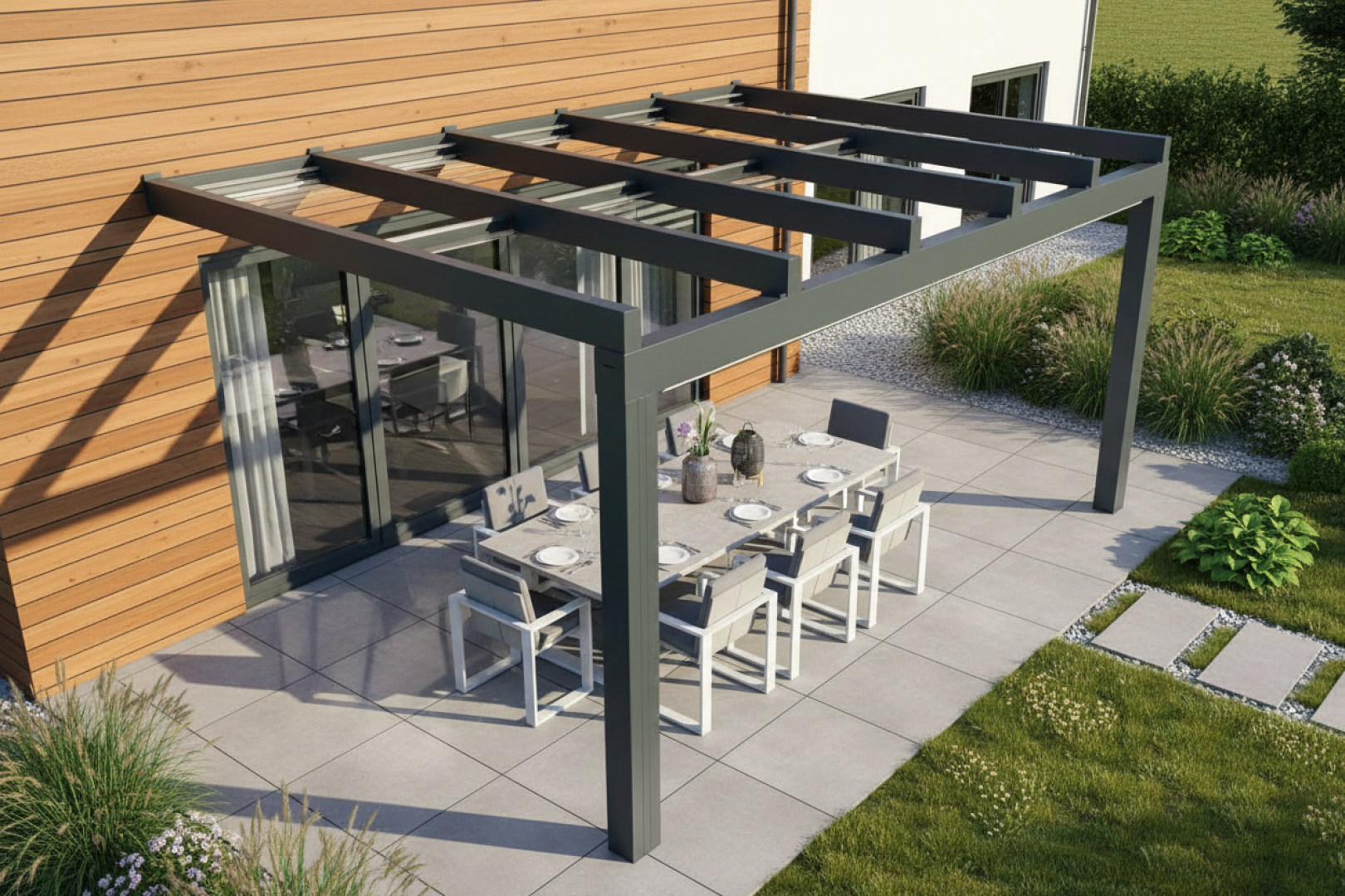 Une pergola moderne en aluminium gris, dotée d'un toit vitré, surplombant la terrasse aménagée en coin repas, près d'une maison revêtue de bois.