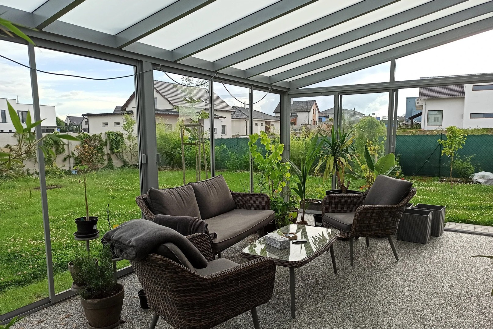 Vitrage moderne du balcon et de la terrasse, avec mobilier gris et vue sur le jardin
