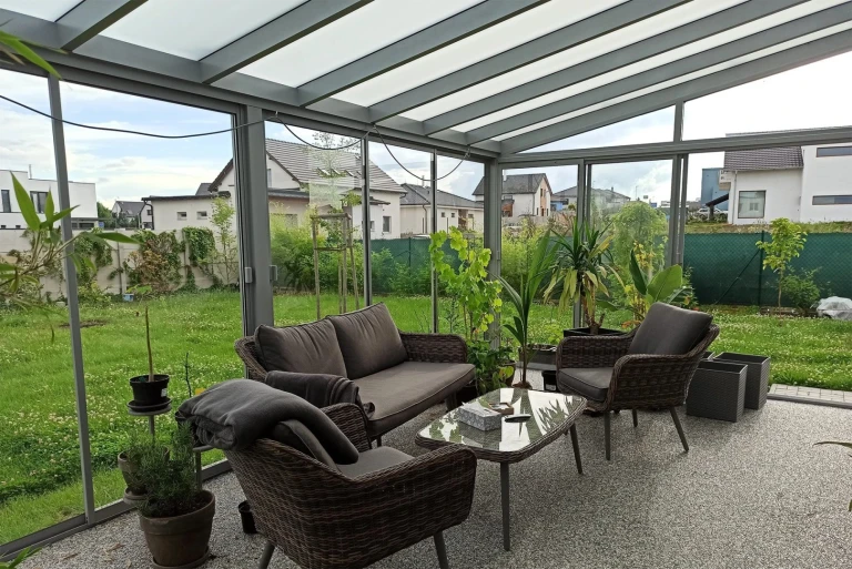 Vitrage moderne du balcon et de la terrasse, avec mobilier gris et vue sur le jardin