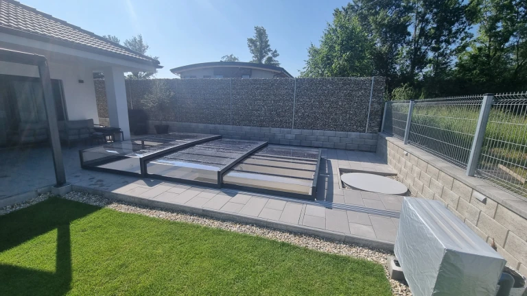 Une couverture de piscine moderne et basse en polycarbonate dans le jardin d'une maison individuelle