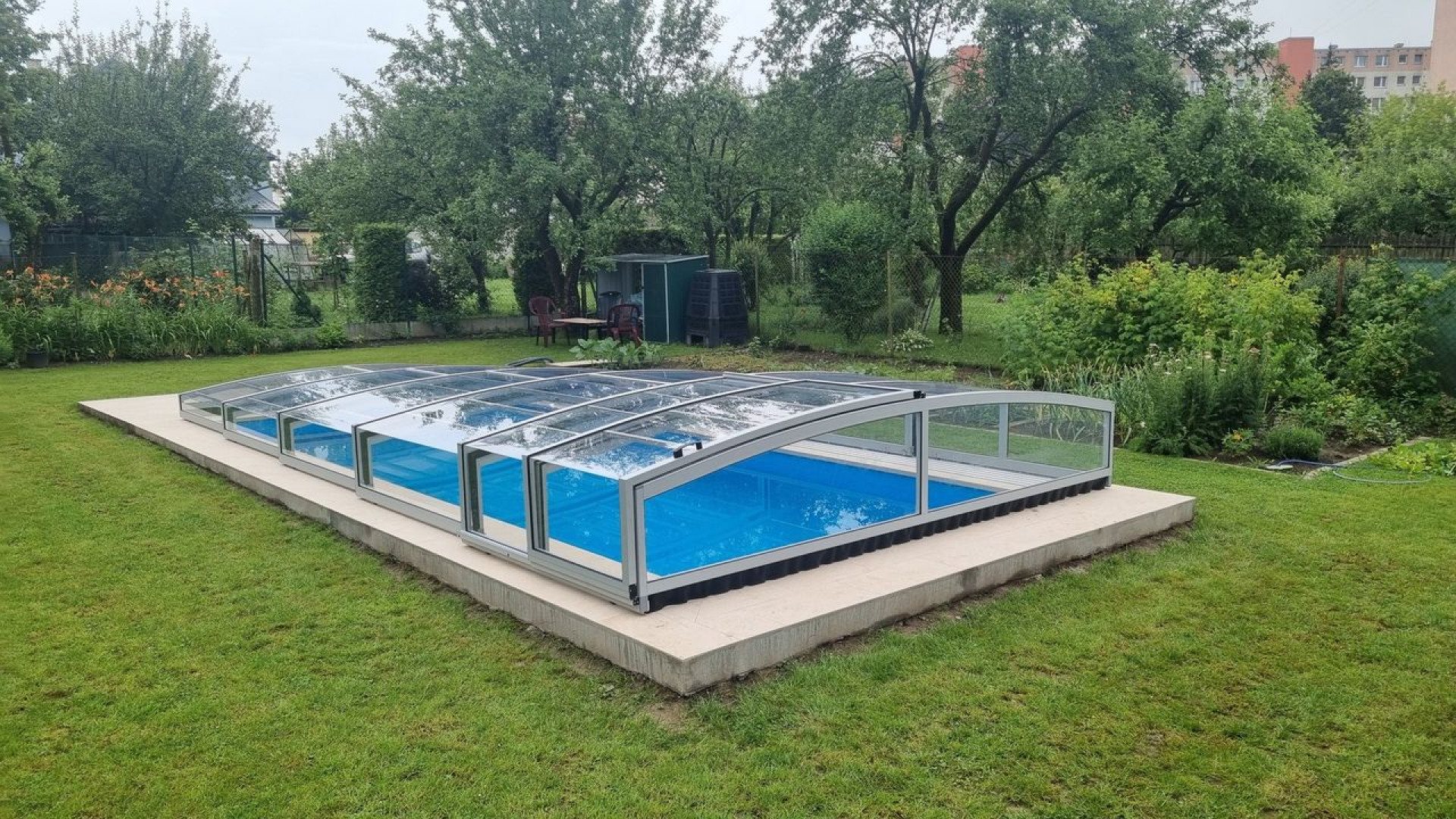 Abri de piscine bas PREMIER au-dessus d'une piscine bleue dans un jardin à Martin.
