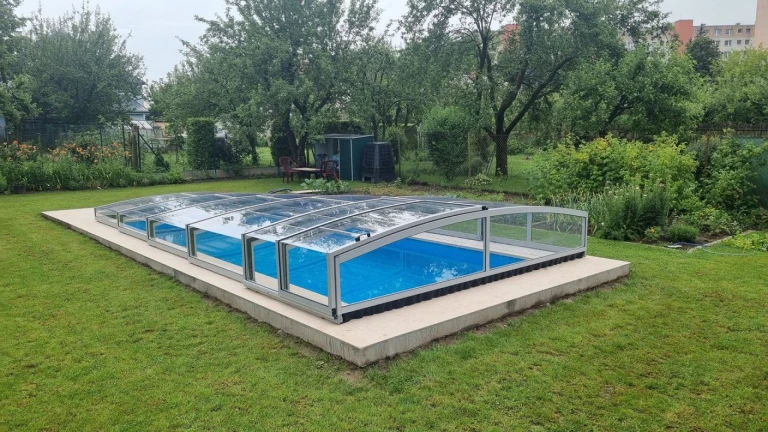Abri de piscine bas PREMIER au-dessus d'une piscine bleue dans un jardin à Martin.