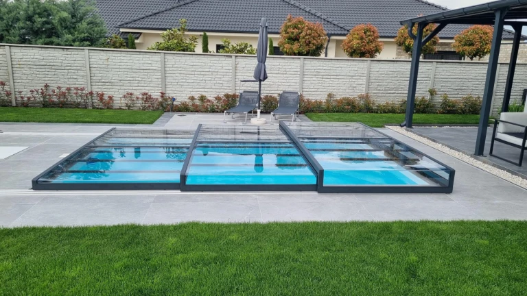 Une couverture de piscine moderne et basse en aluminium dans le jardin d'une maison individuelle