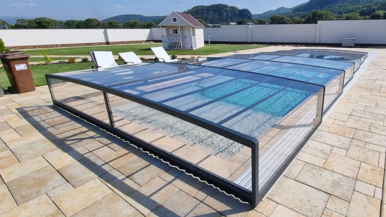 Une verrière moderne et basse surplombant la piscine, située sur une terrasse carrelée avec vue sur les collines
