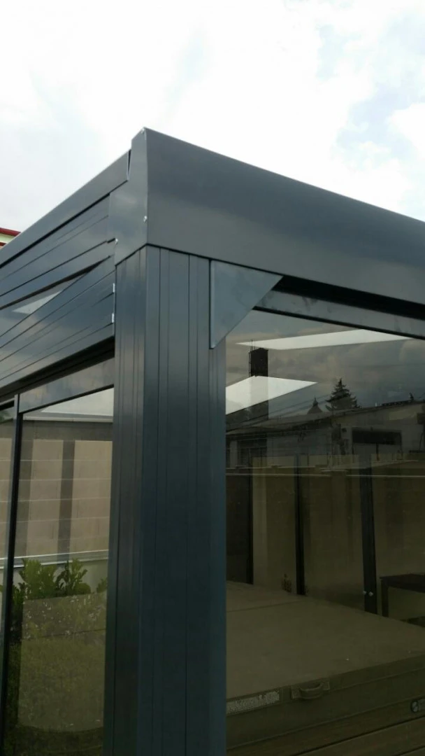 Détail du coin supérieur et du vitrage d'une pergola en aluminium foncé