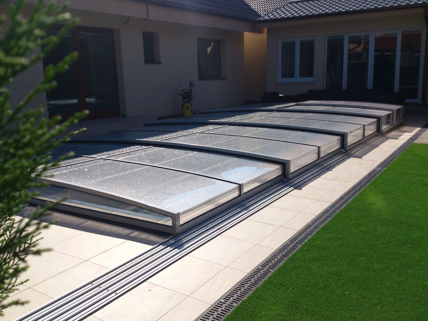 Une petite couverture de piscine STAR sur la terrasse d'une maison moderne avec pelouse à Bratislava.