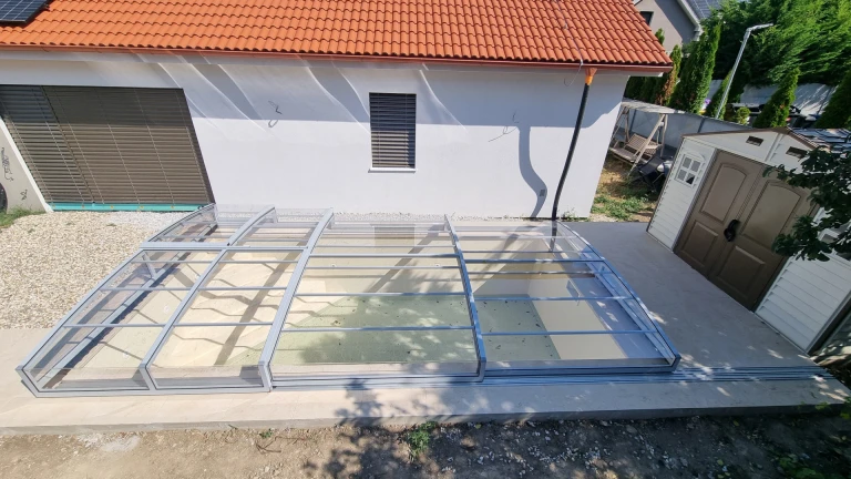 Vue aérienne de la couverture moderne et basse qui surplombe la piscine d'une maison à Senec.