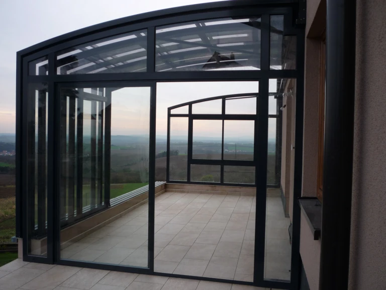 Une terrasse moderne aux baies vitrées offrant une vue sur la campagne