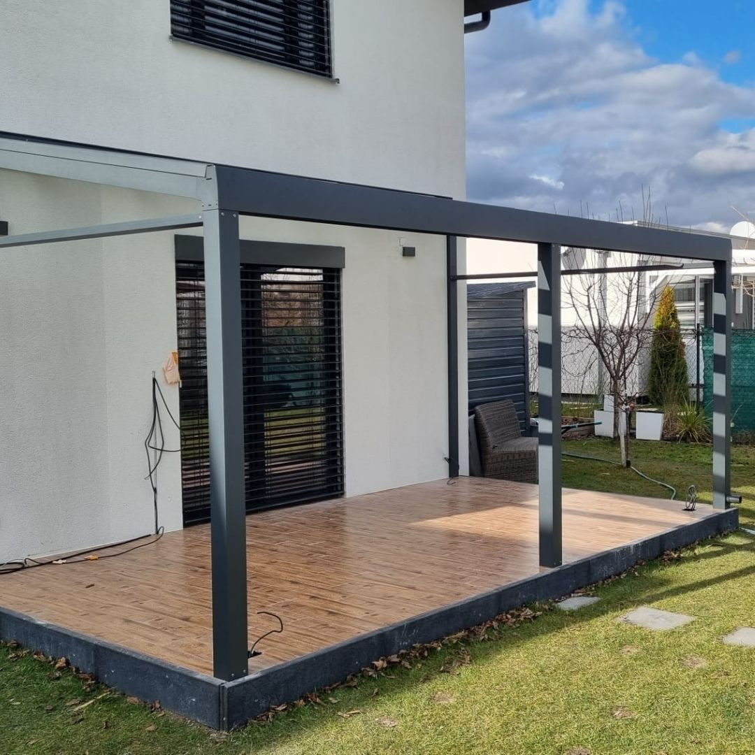Construction d'une véranda en aluminium sur la terrasse en bois d'une maison individuelle.