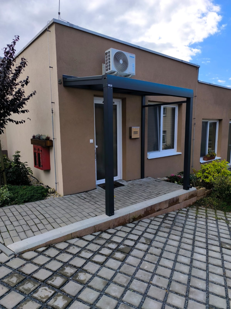 Une structure moderne en aluminium au-dessus de la porte d'entrée d'une maison individuelle