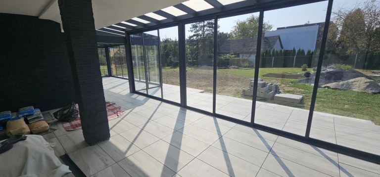 Une véranda moderne vitrée donnant sur la cour, en cours de construction