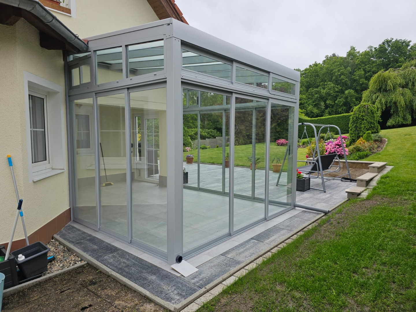 Une véranda moderne vitrée, dotée d'une structure en aluminium, attenante à une maison individuelle